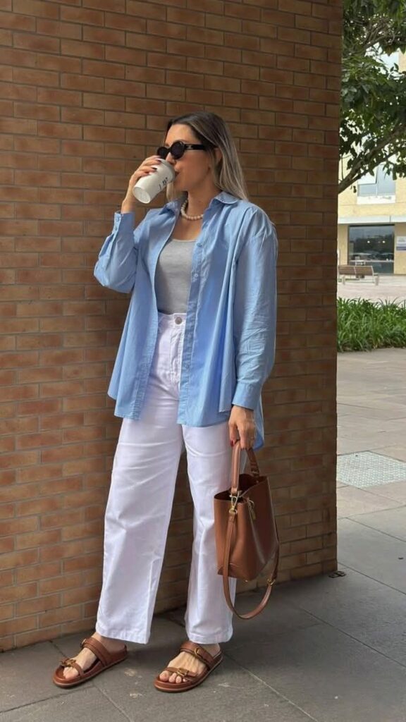 Woman wearing a light blue shirt with white pants and brown sandals, showing a relaxed but shapeless outfit.