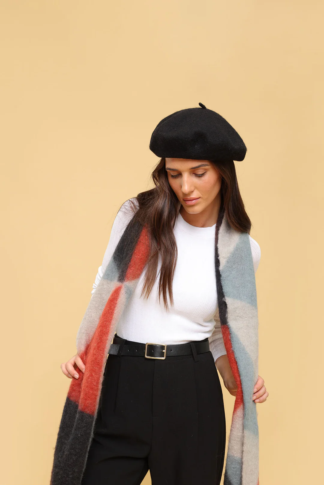 Woman who has accessorised with a beret, scarf and belt.