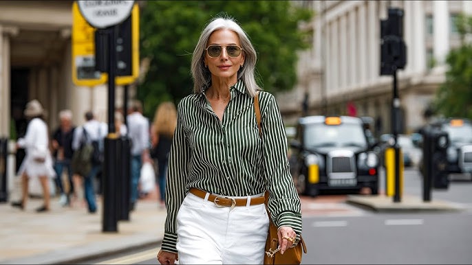 Confident woman wearing a striped green shirt and white trousers with a tan belt, showcasing a flattering, everyday mum-friendly outfit.