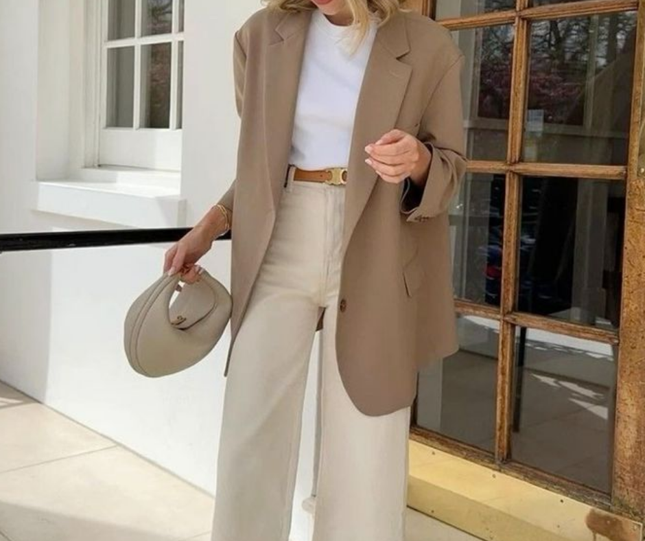 Minimalist neutral outfit with oversized beige blazer and wide-leg trousers, styled with a belt and round handbag to add shape and style.
