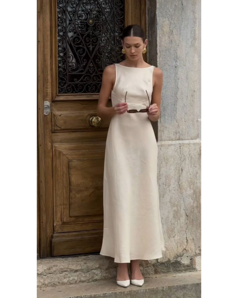 Woman wearing a minimal neutral sleeveless dress styled elegantly for a timeless look