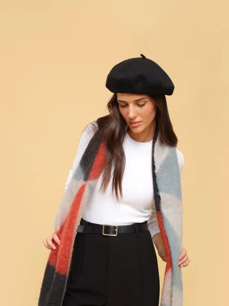 Woman who has accessorised with a beret, scarf and belt.